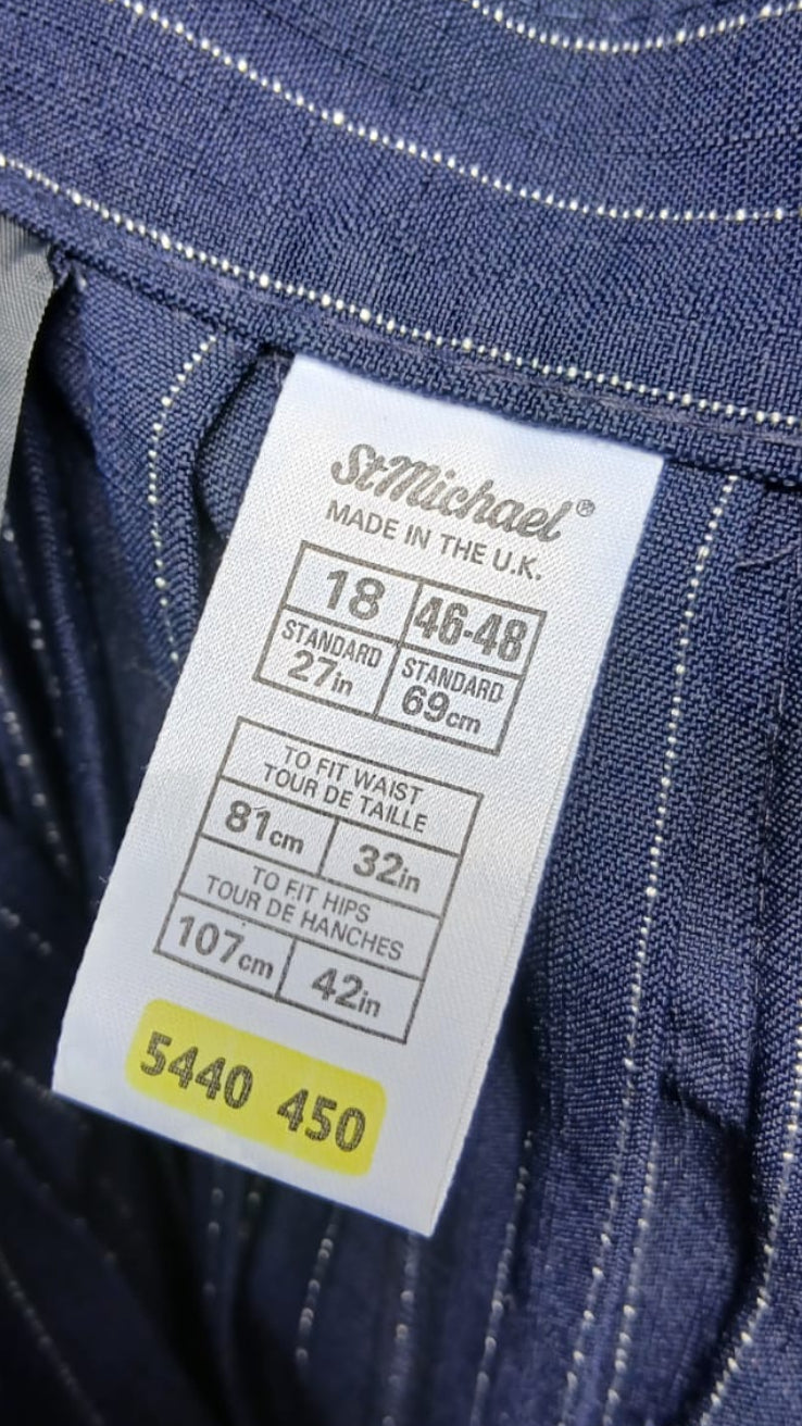 Close-up of the inner label of dark blue pinstriped skirt, showing the brand 'St Michael' and size information.