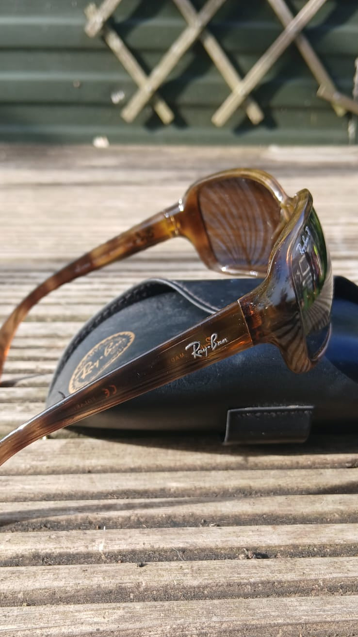 Ray-Ban sunglasses with a tortoiseshell pattern resting on a black case.