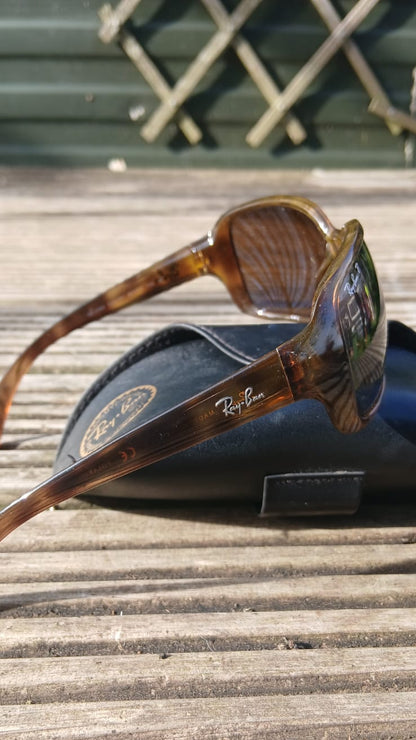 Ray-Ban sunglasses with a tortoiseshell pattern resting on a black case.