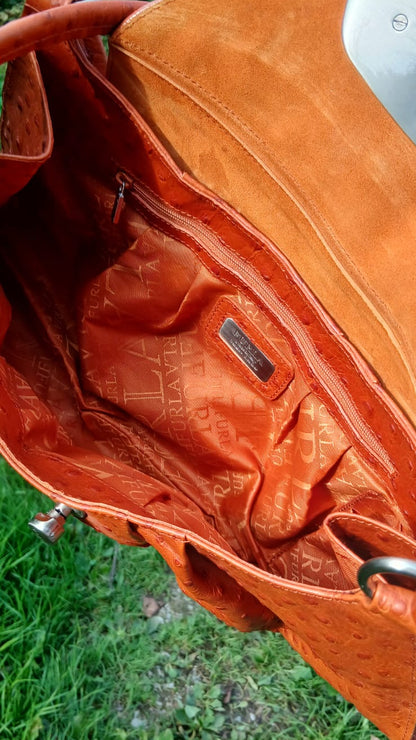 This Italian-made Furla handbag is crafted in rich burnt orange ostrich-embossed leather, this shoulder bag features elegant gathered pleating, dual flat leather shoulder straps, a spacious tonal textile logo interior lining and a sleek silver-tone push-lock closure on the front flap.