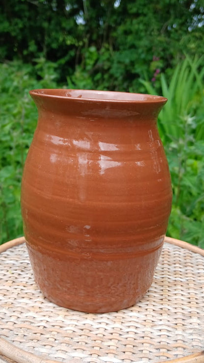 A handmade terracotta clay pot with a glossy finish from Ardmore pottery.