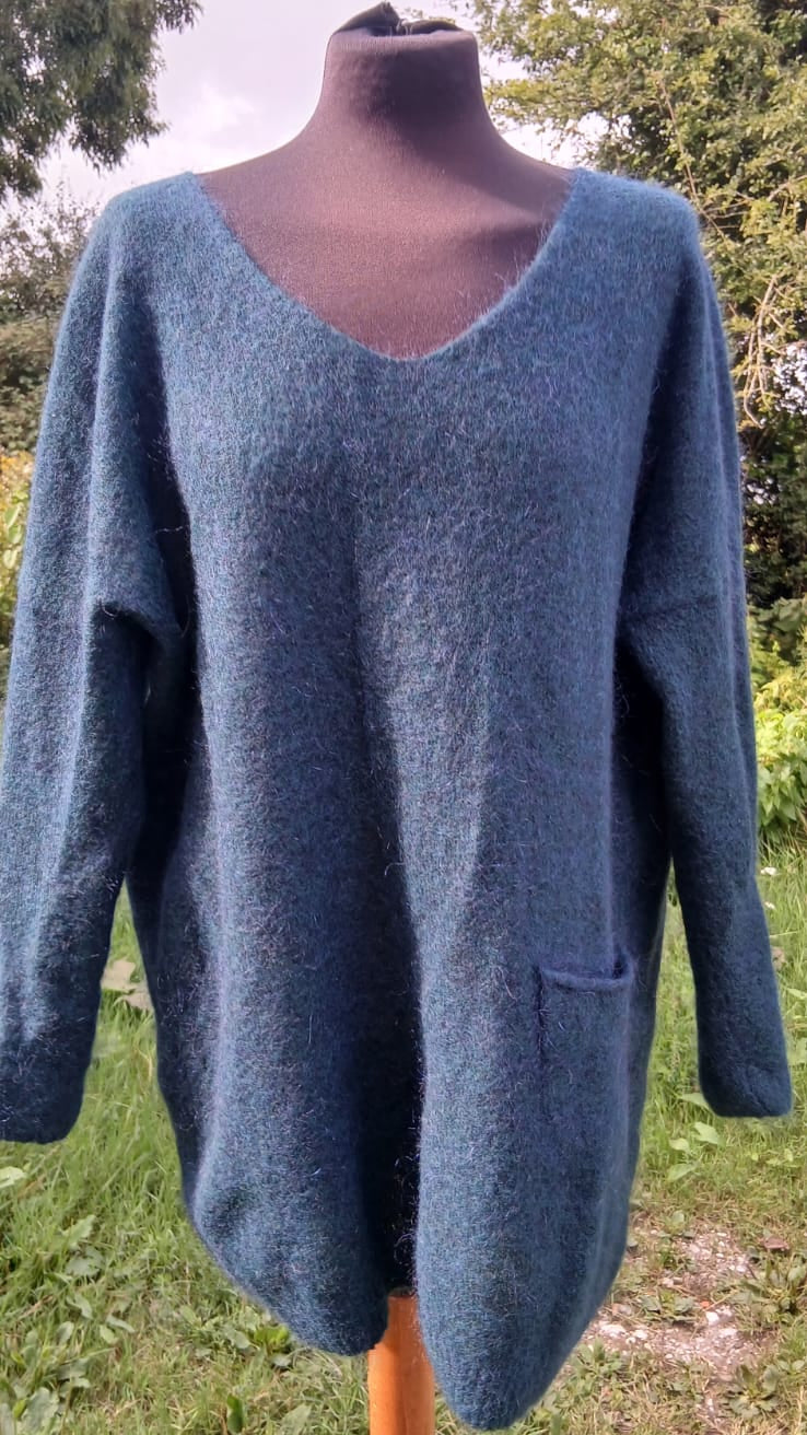 A blue-green v-neck long swearter of Sarah Pacini brand. A single pocket at the side of the sweater is visible.