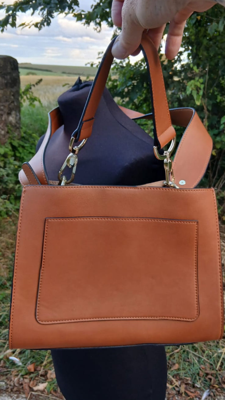 A tan leather handbag with a front pocket and double shoulder straps.