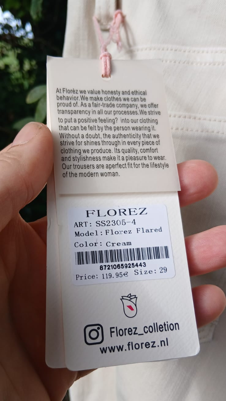 A  white fabric tag for a Florez garment, showing the brand name, product code, care instructions, and color information.