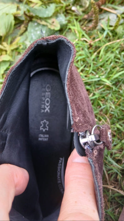 A close-up of a brown suede shoe insert with a black interior lining and a visible GEOX logo.