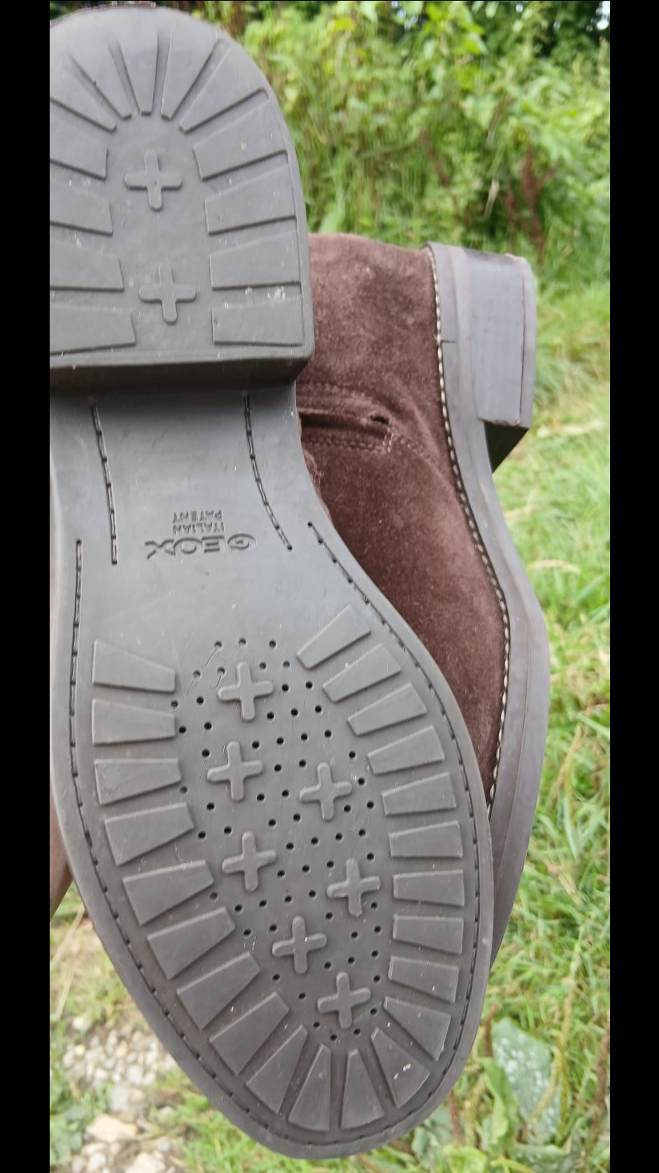 A close-up of a brown suede boot, showing the textured black rubber outsole with tread patterns and a small embossed Geox mark.