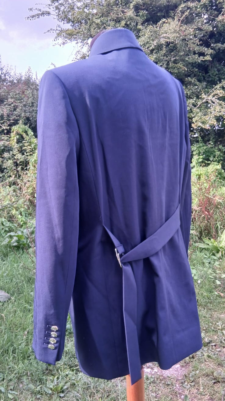 A purple tailored blazer with a matching waist tie belt and four buttons visible on the cuff of the Massimo Dutti brand.