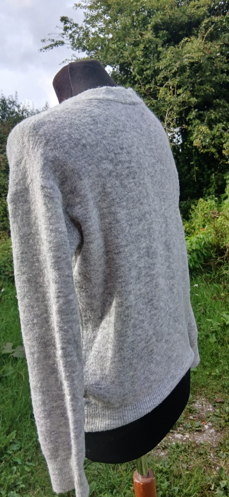 Back view of a light gray Massimo Dutti cardigan with long sleeves.