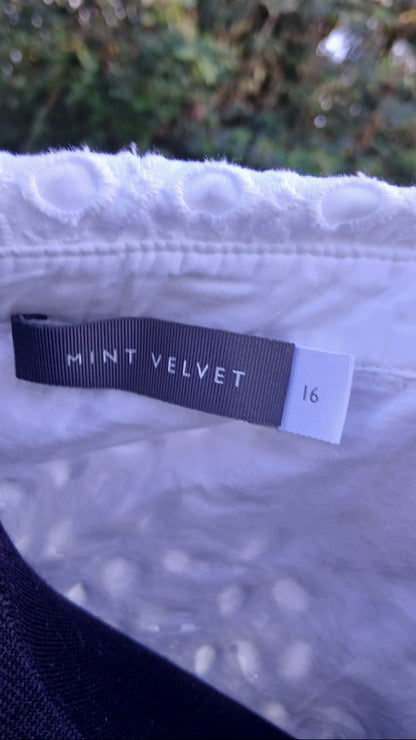 Close-up of a white textured garment with a dark gray brand tag reading 'MINT VELVET' and size '16'.
