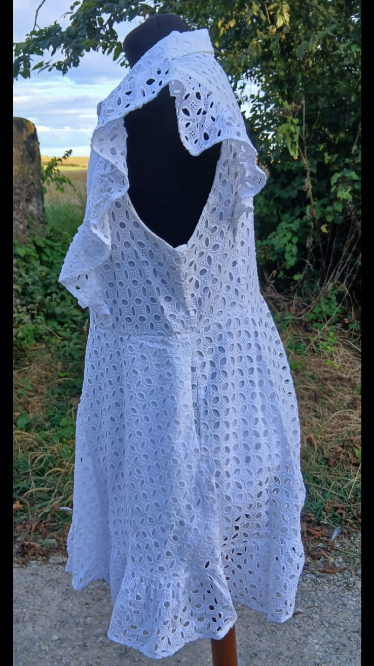 Side view of a white eyelet lace button-down shirt dress featuring ruffled cap sleeves, a pointed collar, and a button-front closure.