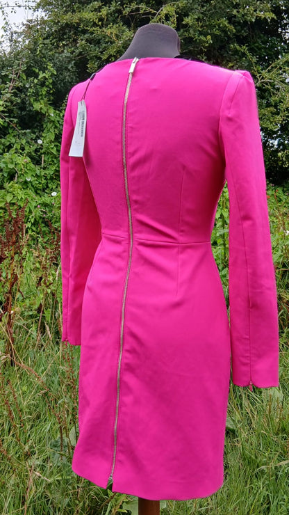 A back view of a Karen Miller bright pink long-sleeve dress with a central zipper.