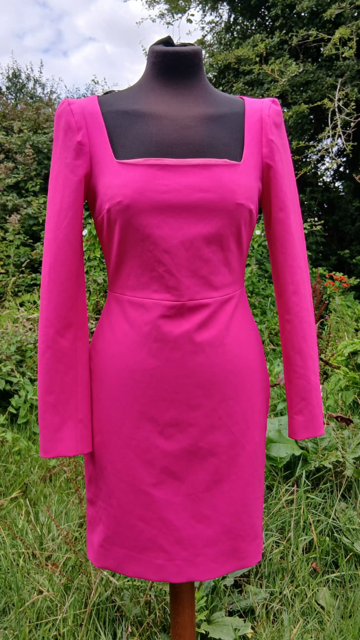 A Karen Miller bright pink knee-length dress with long sleeves and a square neckline.