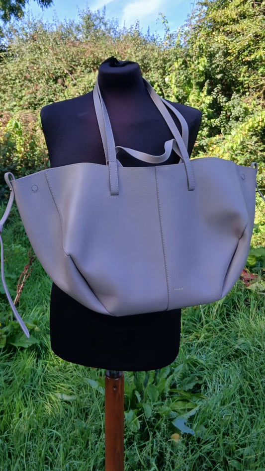 A large light gray leather tote bag with double shoulder straps.