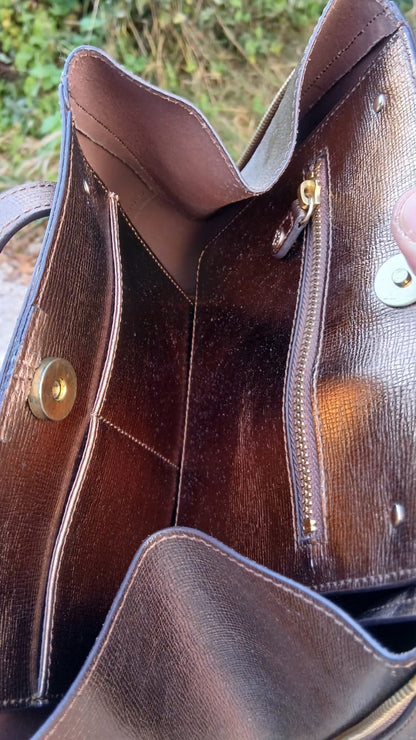 Close-up of the interior of a bronze leather handbag by L.K. Bennett London, showing the lining, zipper pocket, and hardware.