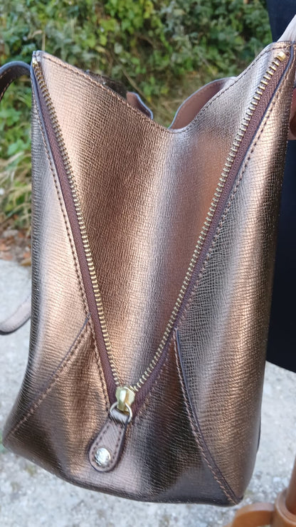 A side view of a metallic bronze textured leather shoulder bag with a diagonal zipper by L.K. Bennett.