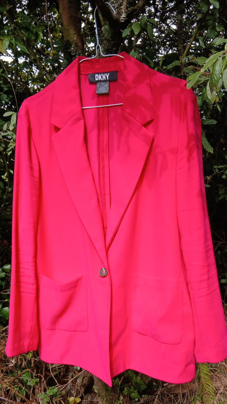 A DKNYbright hot pink blazer jacket with a single button closure, notched lapels, and front patch pockets.