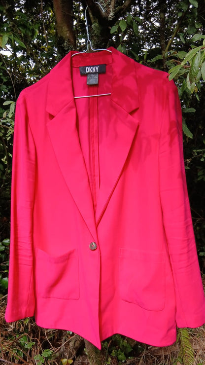 A DKNYbright hot pink blazer jacket with a single button closure, notched lapels, and front patch pockets.