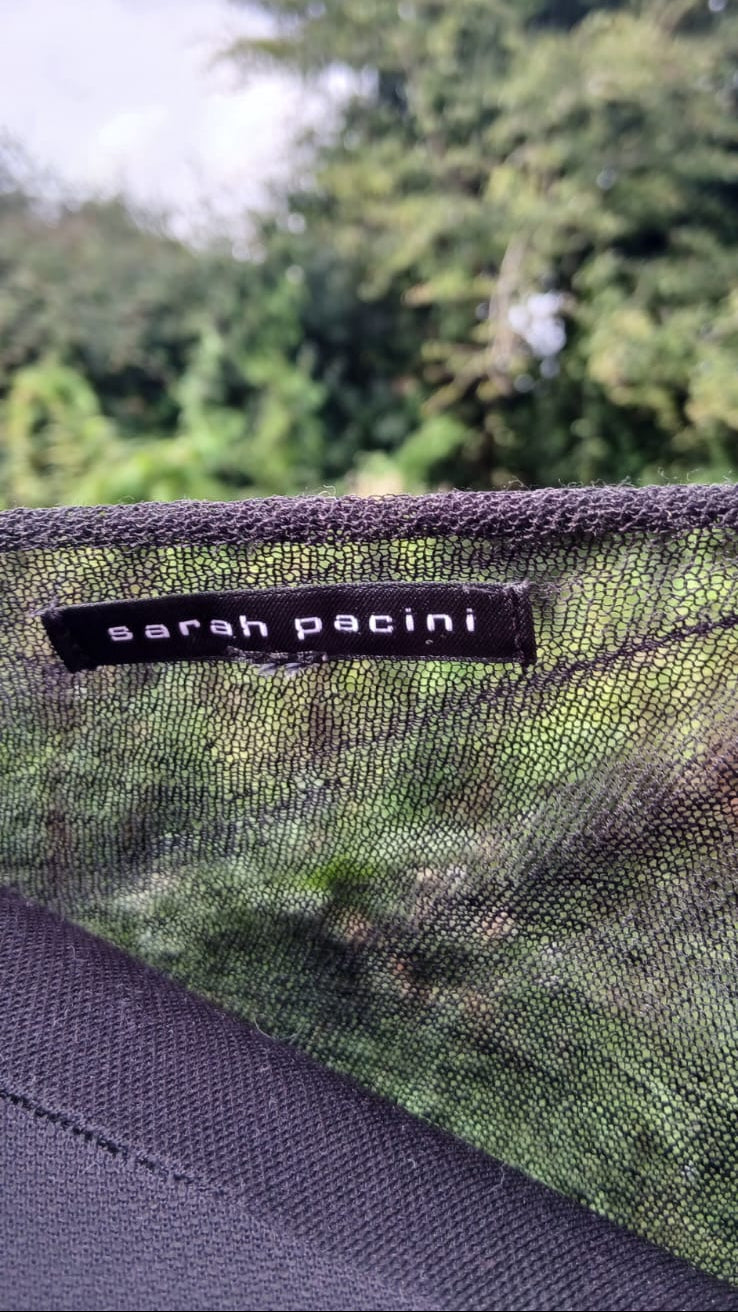 Close-up of a black mesh Sarah Pacini dress with a black brand label reading 'sarah pacini'.