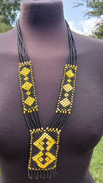 A long beaded necklace with black and yellow geometric patterns.