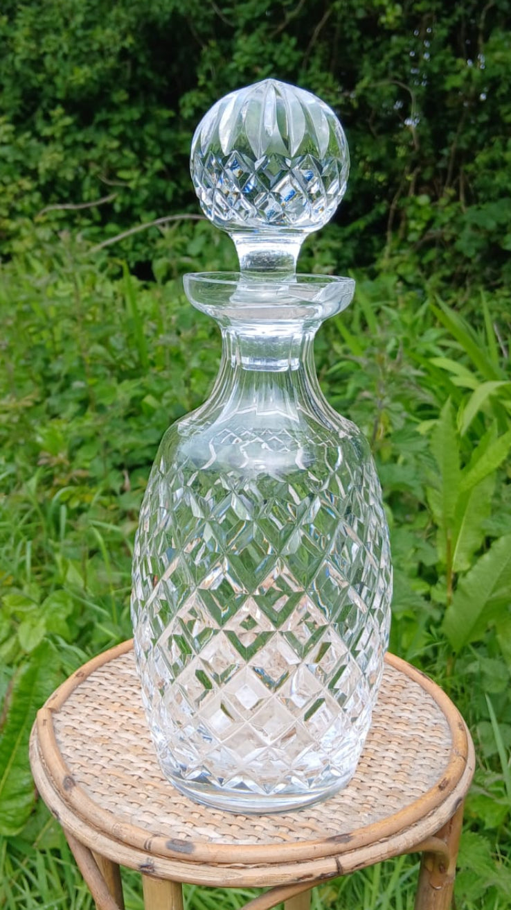 A clear cut-glass decanter with a matching stopper.