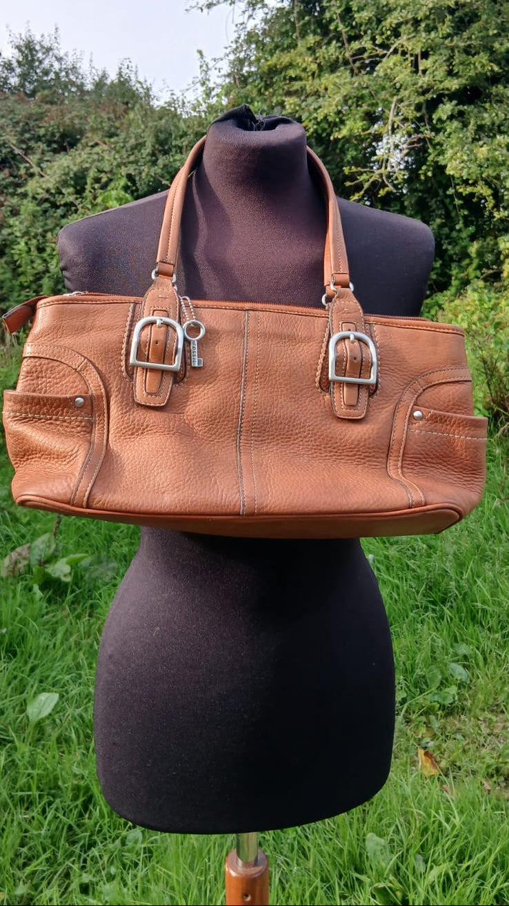 A tan leather shoulder bag with silver buckle details.