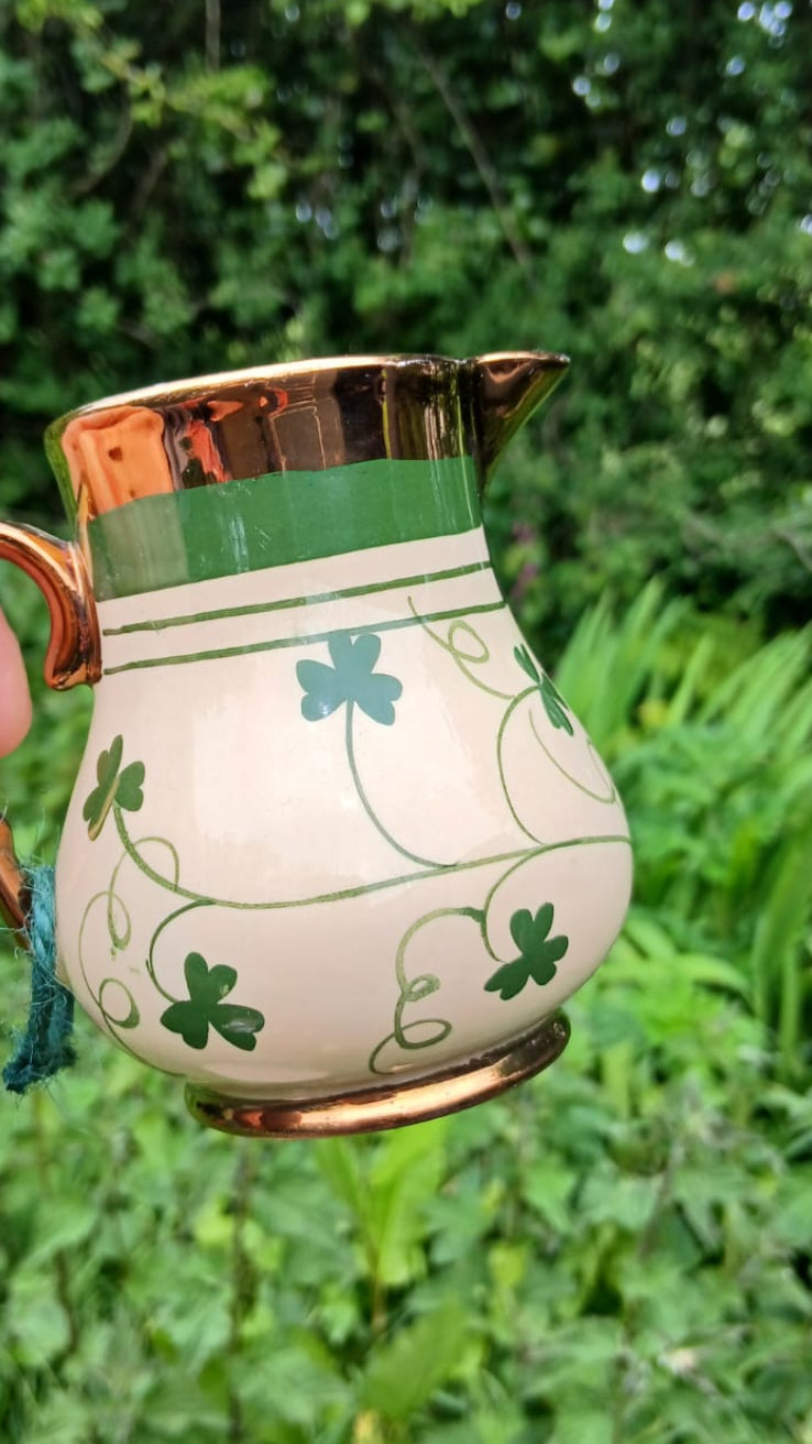 Small cream-colored Harvest Wade pitcher with green shamrock and vine patterns, gold trim, and a green band near the rim
