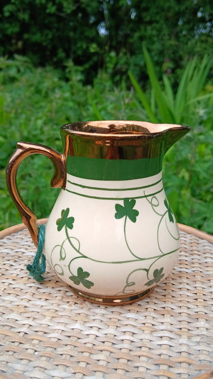 Vintage Wade england harvest ware pitcher decorrated with shamrocks a green band and a copper luster rim and handle 