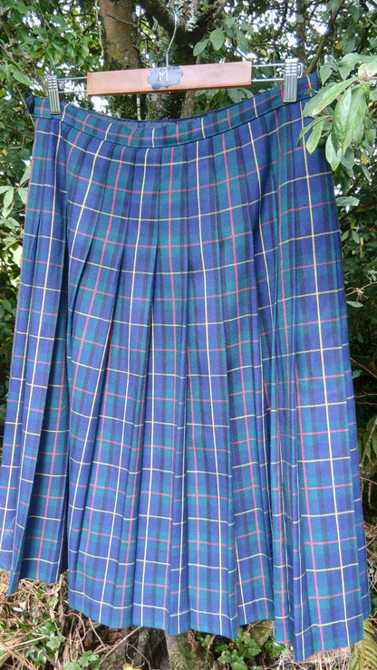 A pleated tartan skirt in blue, green, and yellow plaid .