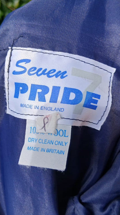 Close-up of a pleated tartan skirt with a sewn-on brand label reading 'Seven PRIDE'  and product tag.