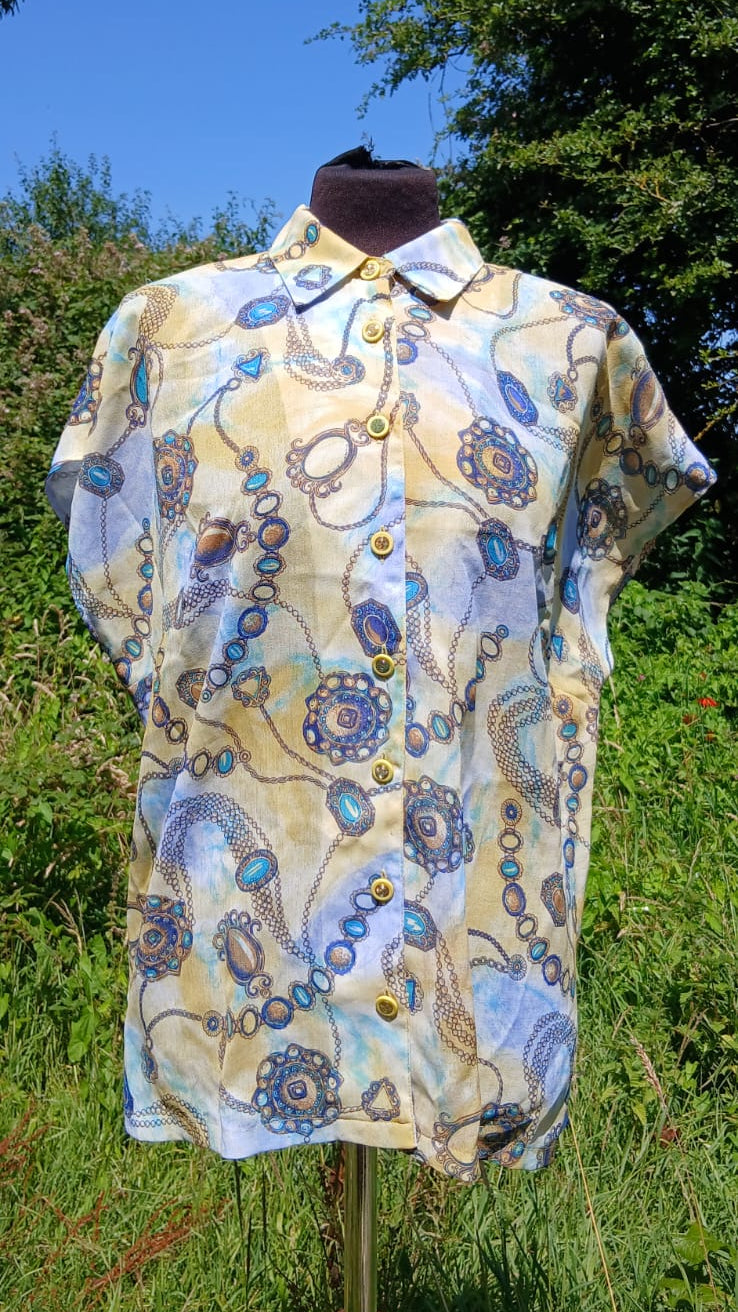 A short-sleeve button-up shirt with a blue and yellow jewelry and chain print.