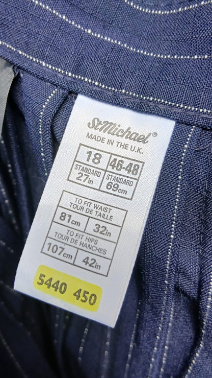Close-up of the inner label of dark blue pinstriped skirt, showing the brand 'St Michael' and size information.