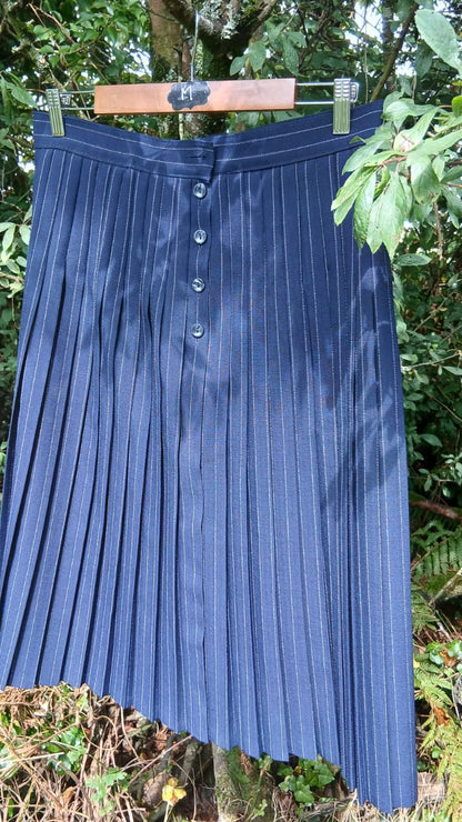 A vintage navy blue pleated skirt with a button front from the St Micheal brand.
