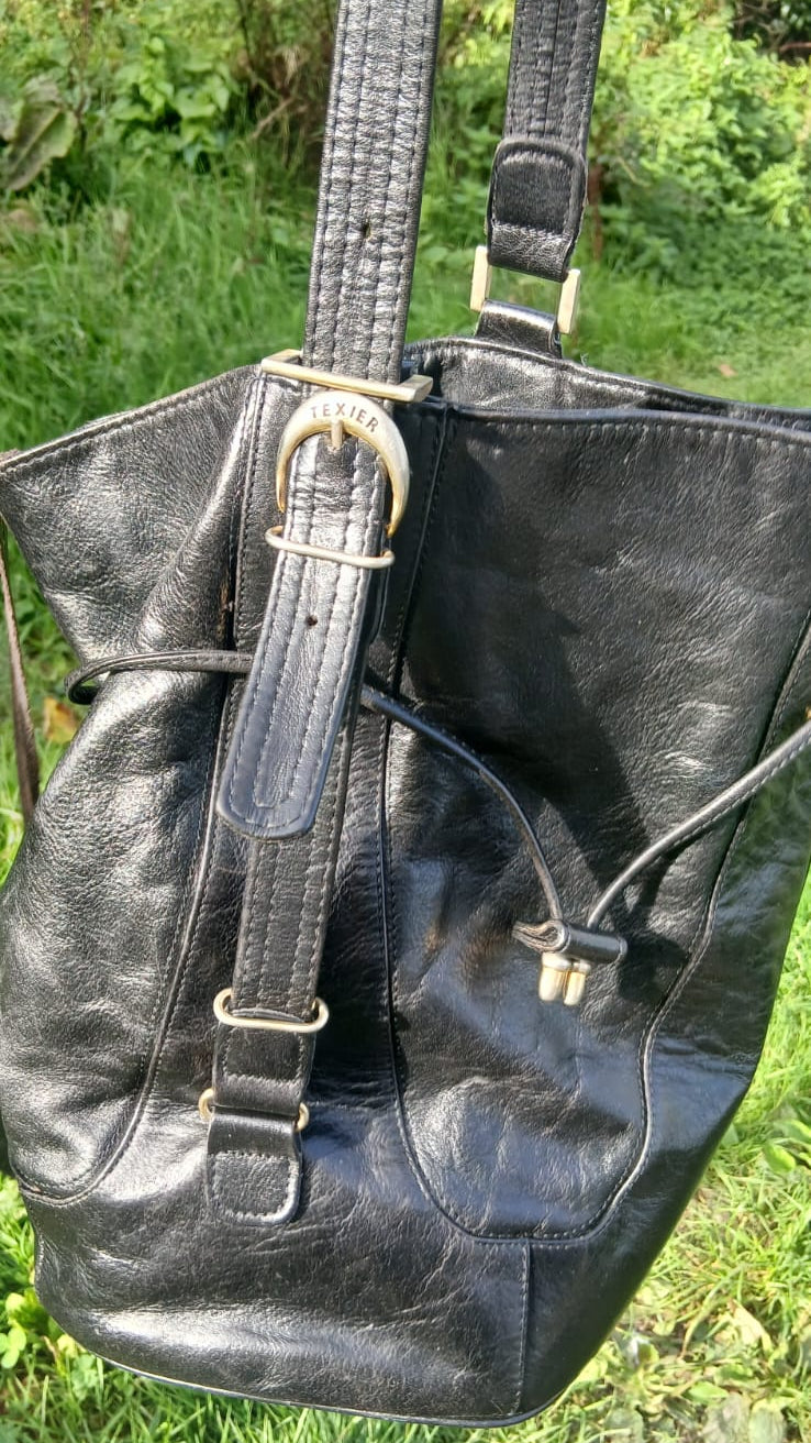 A black leather bucket bag with gold-tone hardware.