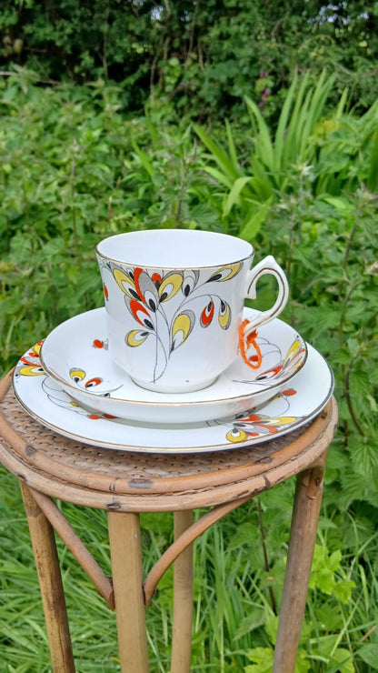 A Wetley China white porcelain teacup trio with a colorful floral pattern.