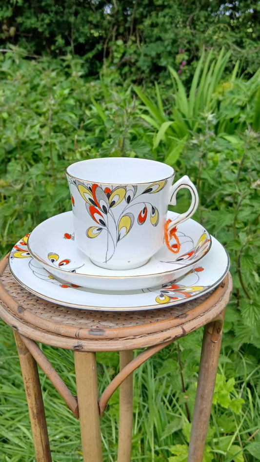 A Wetley China white porcelain teacup trio with a colorful floral pattern.