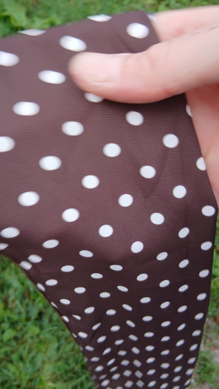 A close-up of a belt featuring a white polka dot pattern.